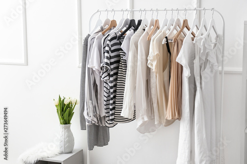 Rack with clean female clothes in dressing room