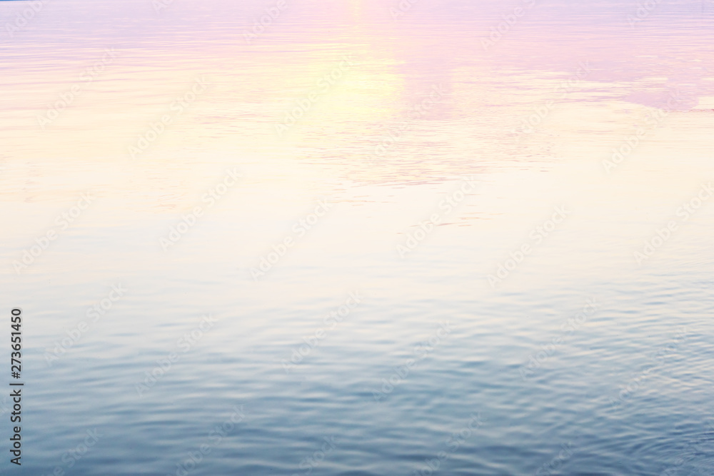 Calm water surface, blue and pink hue. Abstract background. Water texture