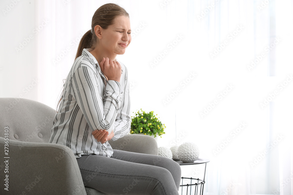 Young woman suffering from pain in elbow at home Young woman suffering from pain in elbow at home