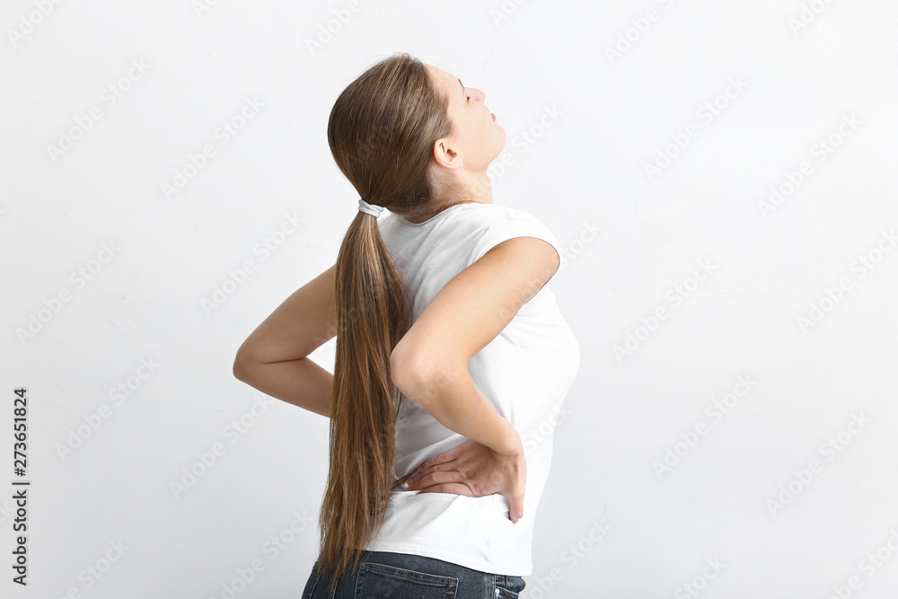 Young woman suffering from back pain on white background Young woman suffering from back pain on white background