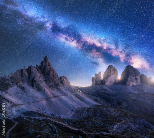 Bright Milky Way over mountains at starry night in summer. Amazing landscape with alpine mountains, blue sky with milky way and stars, high rocks. Tre Cime in Dolomites, Italy. Space. Beautiful nature