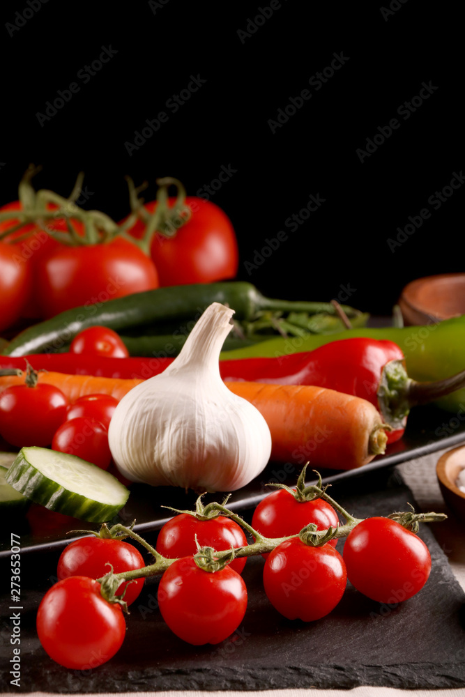 Healthy food. Vegetables on a black plate and stone cutting board and wooden background. Healthy food. Vegetables on a black plate and stone cutting board and wooden background.