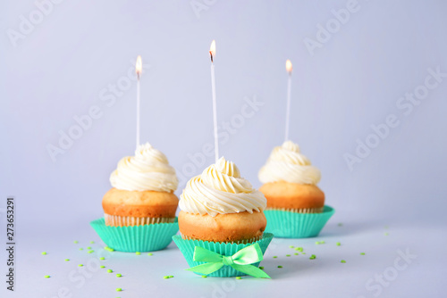 Tasty Birthday cupcakes on grey background
