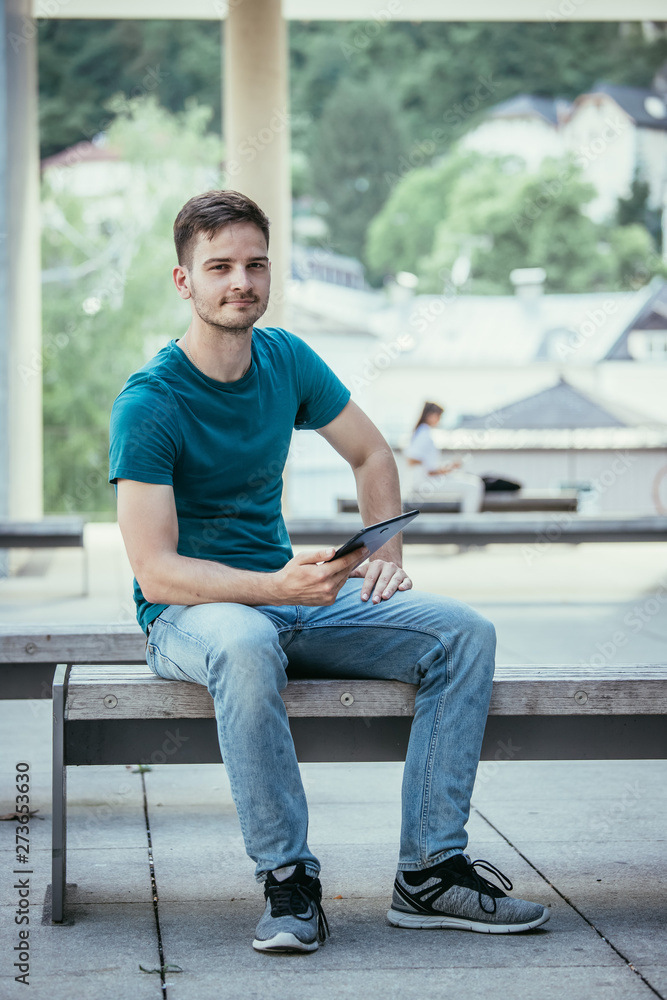 Student using a tablet pc on the campus. Outdoors, urban feeling, summertime Student using a tablet pc on the campus. Outdoors, urban feeling, summertime