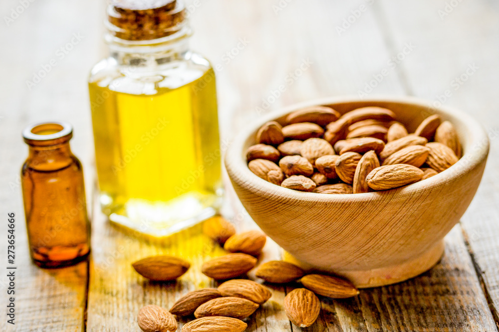 cosmetic and therapeutic almond oil on light wooden background cosmetic and therapeutic almond oil on light wooden background