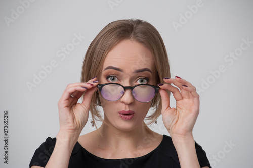 Portrait of surprised young woman in stylish spectacles