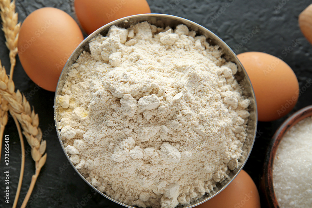 Bowl with flour and products on dark background Bowl with flour and products on dark background