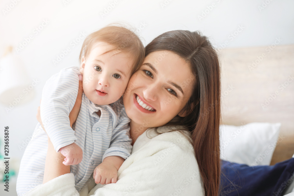 Happy mother with adorable baby boy at home
