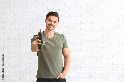Handsome man with bottle of...