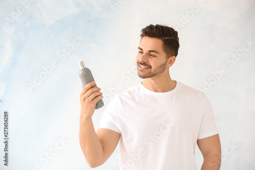 Handsome man with bottle of...