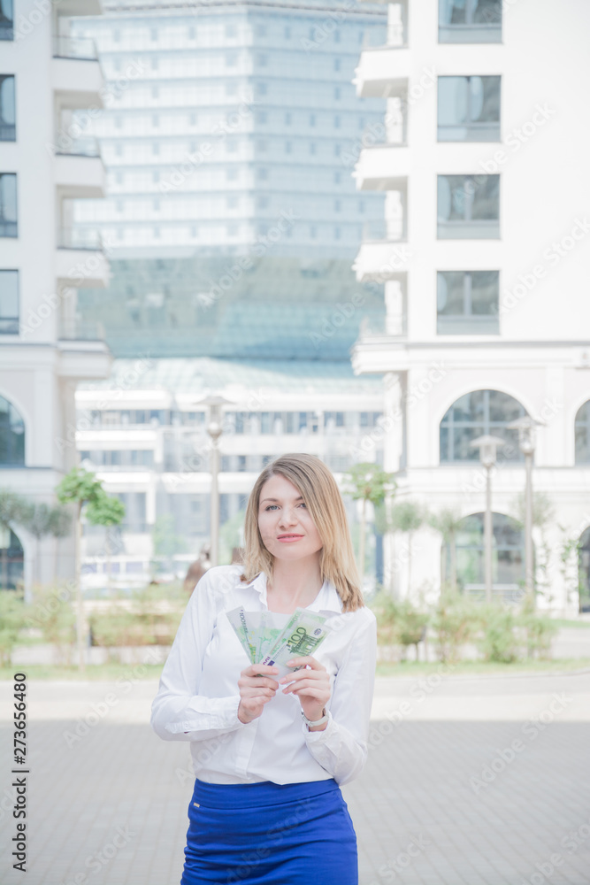 business woman holding euro banknotes on city buildings background business woman holding euro banknotes on city buildings background