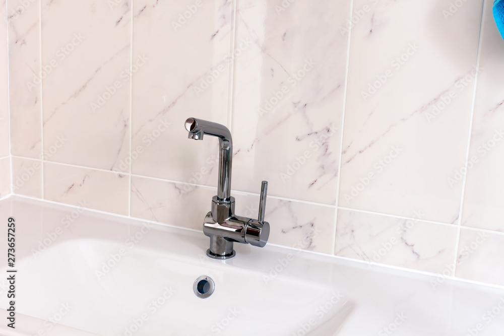 New faucet and white sink in bathroom. New faucet and white sink in bathroom.