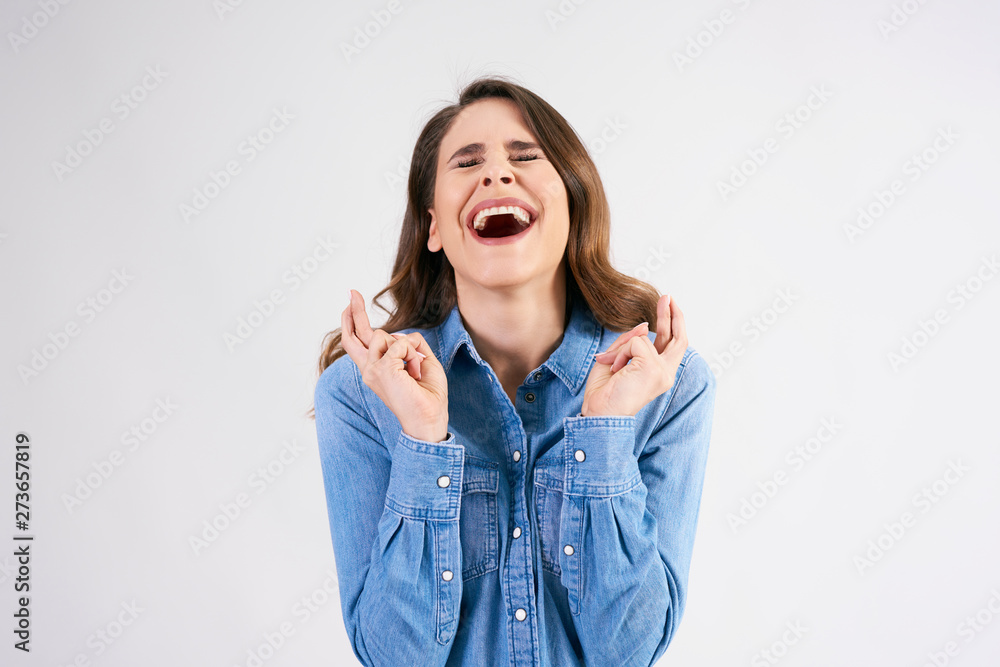 Young woman crossing her fingers and wishing for good luck Young woman crossing her fingers and wishing for good luck
