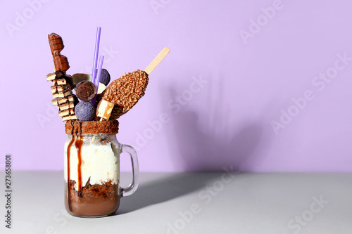 Mason jar with delicious freak shake on table photo