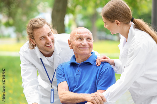 Elderly man with caregivers...
