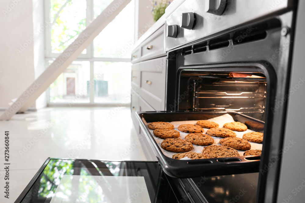 Open oven with tasty homemade cookies in kitchen Open oven with tasty homemade cookies in kitchen