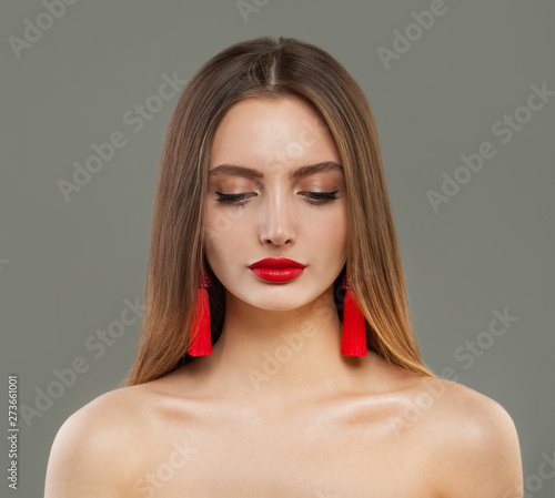 Beautiful fashion model woman with red jewelry earrings portrait