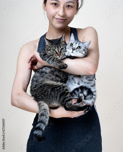 Asian chinese girl modeling holding two cats, grey american short hair and chinese dragon lee lihua cat, photo