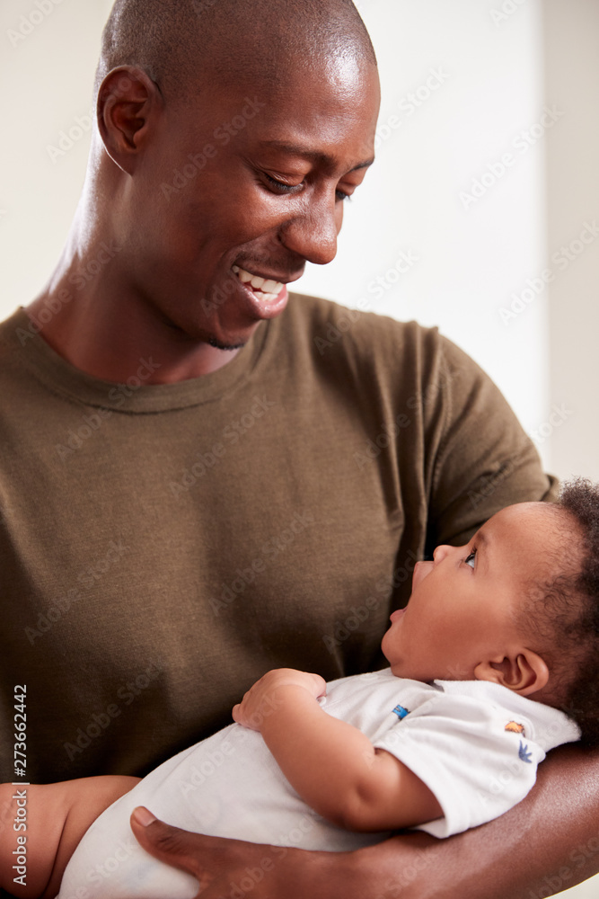 Proud Father Cuddling Baby Son In Nursery At Home Proud Father Cuddling Baby Son In Nursery At Home