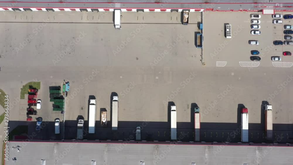 Aerial view of the logistics warehouse with trucks waiting for loading Aerial view of the logistics warehouse with trucks waiting for loading