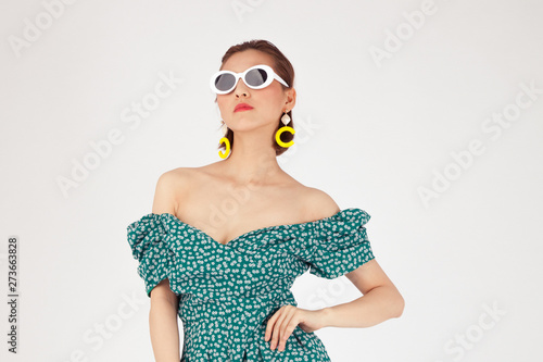 Asian Chinese Fashion influencer modeling in a green dotted dress isolated in white background