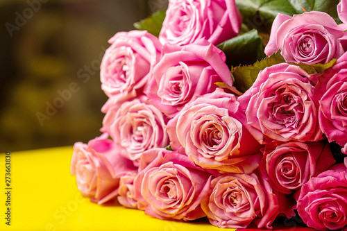 pink roses on yellow table  background blurred