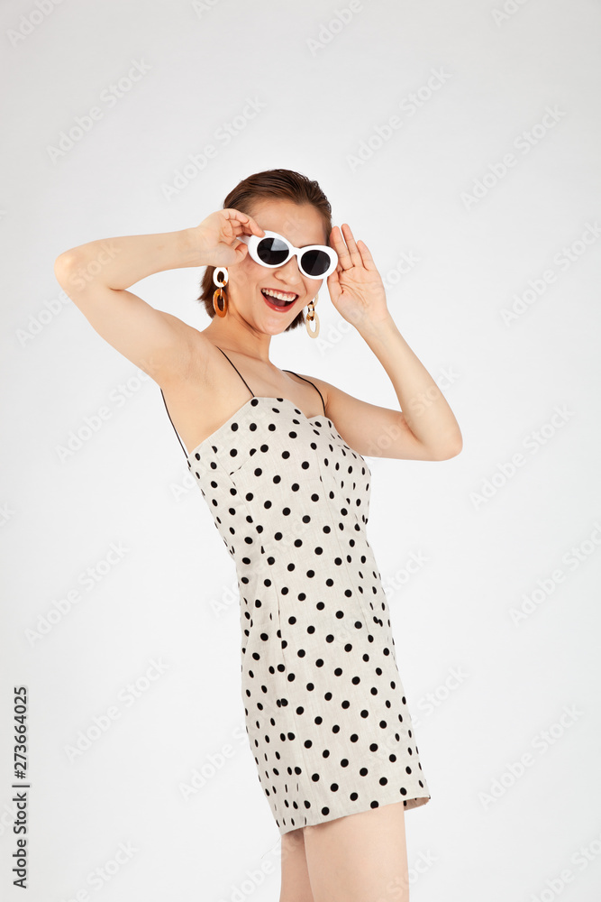 Asian Chinese Fashion influencer modeling in a white dotted mini skirt isolated in white background Asian Chinese Fashion influencer modeling in a white dotted mini skirt isolated in white background