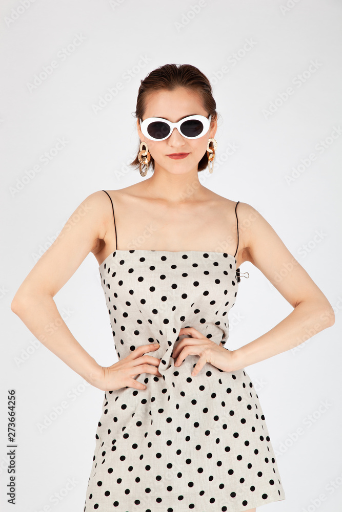 Asian Chinese Fashion influencer modeling in a white dotted mini skirt isolated in white background Asian Chinese Fashion influencer modeling in a white dotted mini skirt isolated in white background