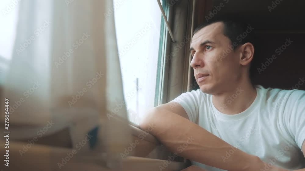 man rides train railway looks out the window. traveler concept train lifestyle railroad journey travel. slow motion video. beautiful from window of a moving train railway trip Russia winter man rides train railway looks out the window. traveler concept train lifestyle railroad journey travel. slow motion video. beautiful from window of a moving train railway trip Russia winter