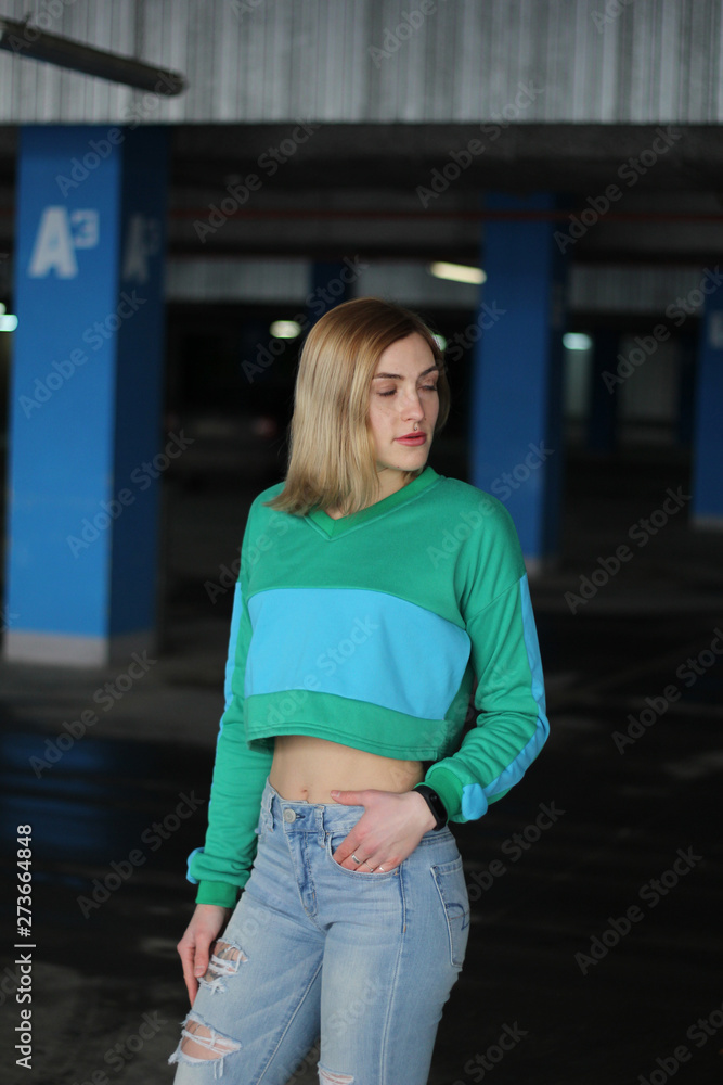 The girl is blonde in a green blue croptop. Street style. Advertising brand clothing. Fashion Shooting The girl is blonde in a green blue croptop. Street style. Advertising brand clothing. Fashion Shooting