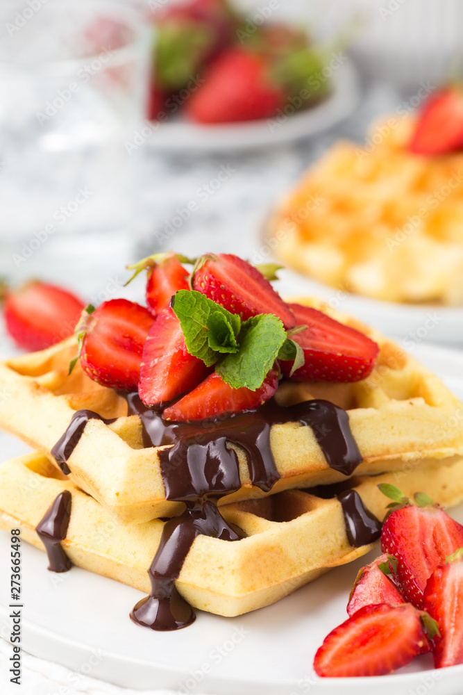 Belgium waffles with chocolate topping and strawberries. Breakfast food Belgium waffles with chocolate topping and strawberries. Breakfast food