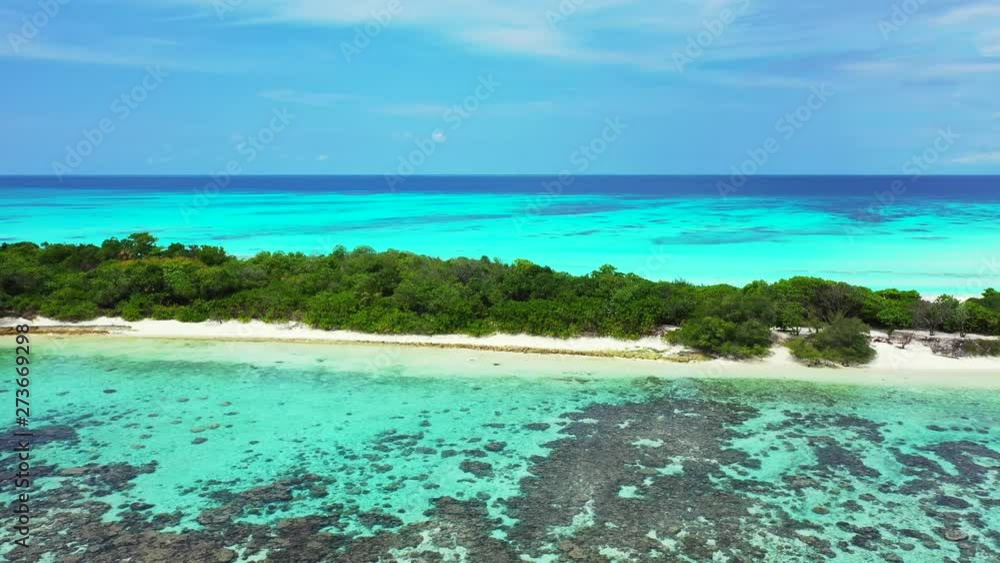 Aerial view of a long and narrow island on the reef in the Caribbean Sea. White sand pristine beaches, palm trees and turquoise waters Aerial view of a long and narrow island on the reef in the Caribbean Sea. White sand pristine beaches, palm trees and turquoise waters