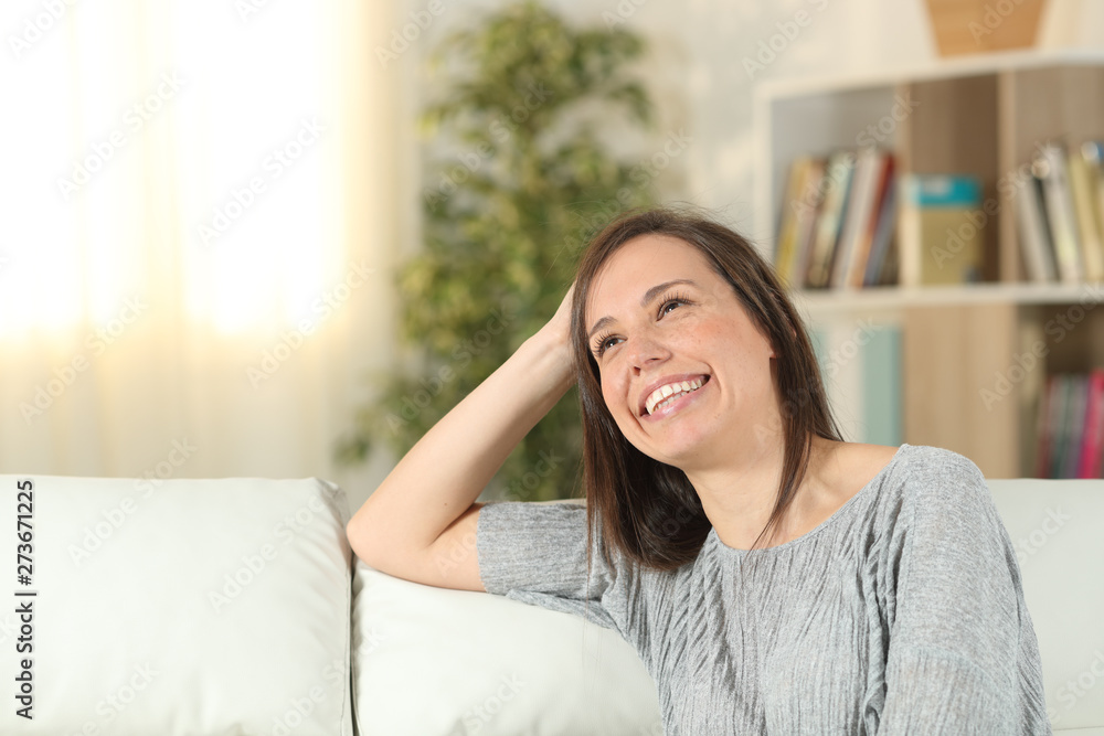 Happy woman dreaming at home looking up Happy woman dreaming at home looking up