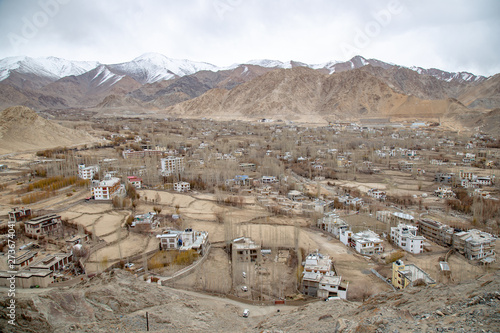 Leh Ladakh city view from Shanti Stupa. Beautiful amazing village in the valley with snow mountain at background. Ladakh, India.