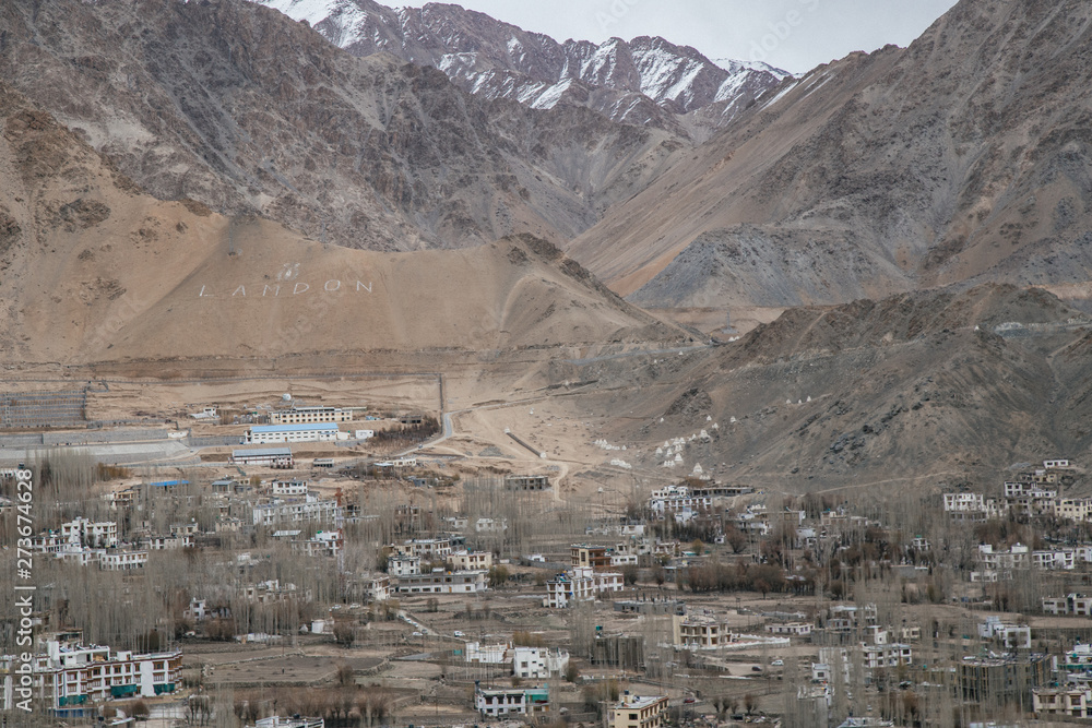 Leh Ladakh city view from Shanti Stupa. Beautiful amazing village in the valley with snow mountain at background. Ladakh, India.