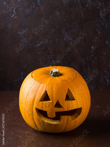 Halloween carved squash on dark brown background