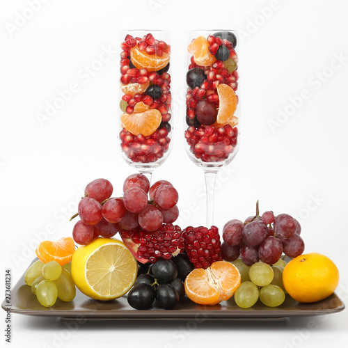 two glasses filled with fruit on a light background