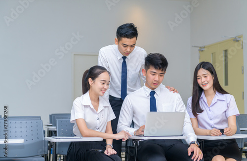 Students in uniform working with laptop