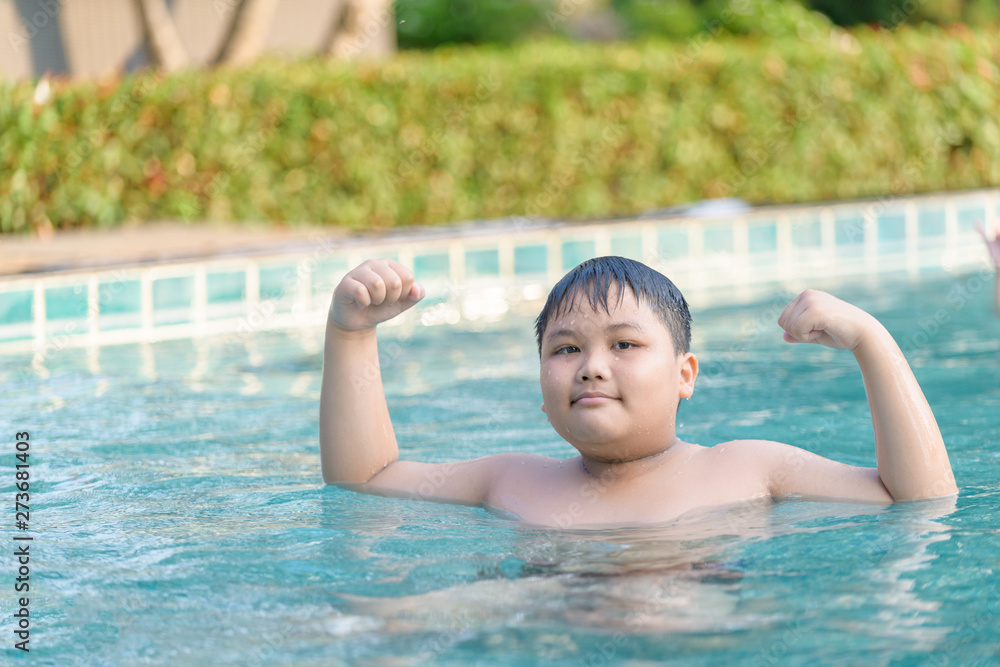 Obese fat boy show muscle in swimming pool