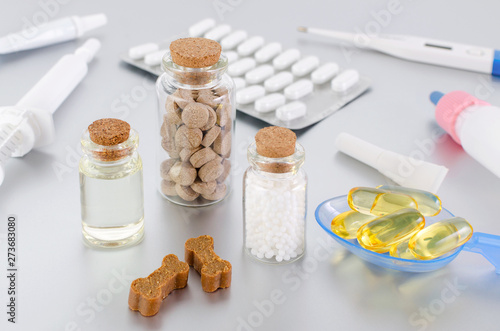 various medical products for animal, natural supplement, oil, medicine and treats like bones on gray background