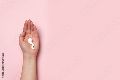 Obraz na plátně Sperm shape on female hand. Medical concept of fertilization