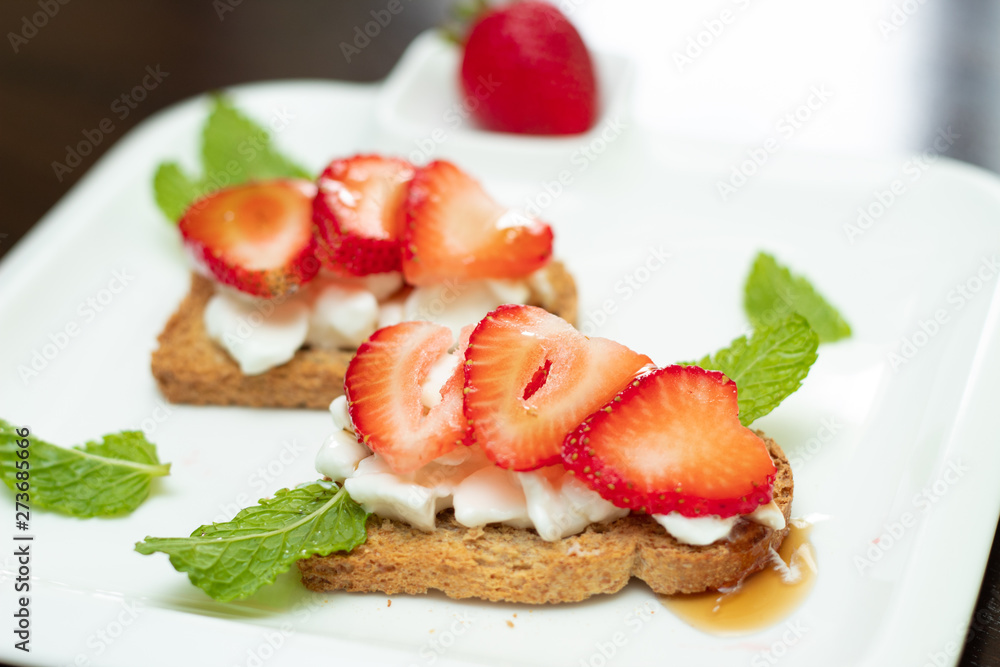 strawberries in slices served with cottage cheese on toasted mini bread