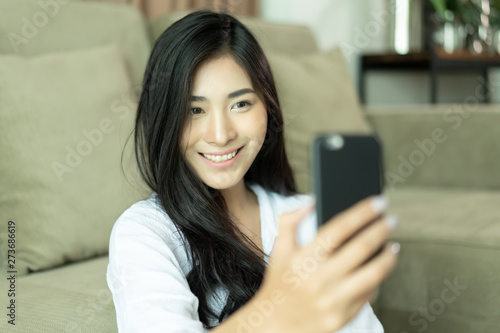 Selfie mania! Excited,Young attractive Asian woman making selfie on a smartphone camera or recording video vlog on a mobile phone. popular vlogger smiling to followers communicating by webcam online © Have a nice day 