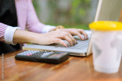 Asian female Business women freelancer reading report paper and working with laptop at home office,big bright window and drinking coffee relaxed lifestyle,Work at home concept