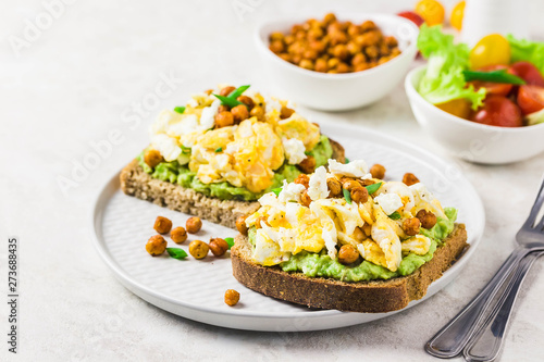 Scrambled eggs avocado feta chickpeas breakfast sandwiches. Selective focus, space for text.