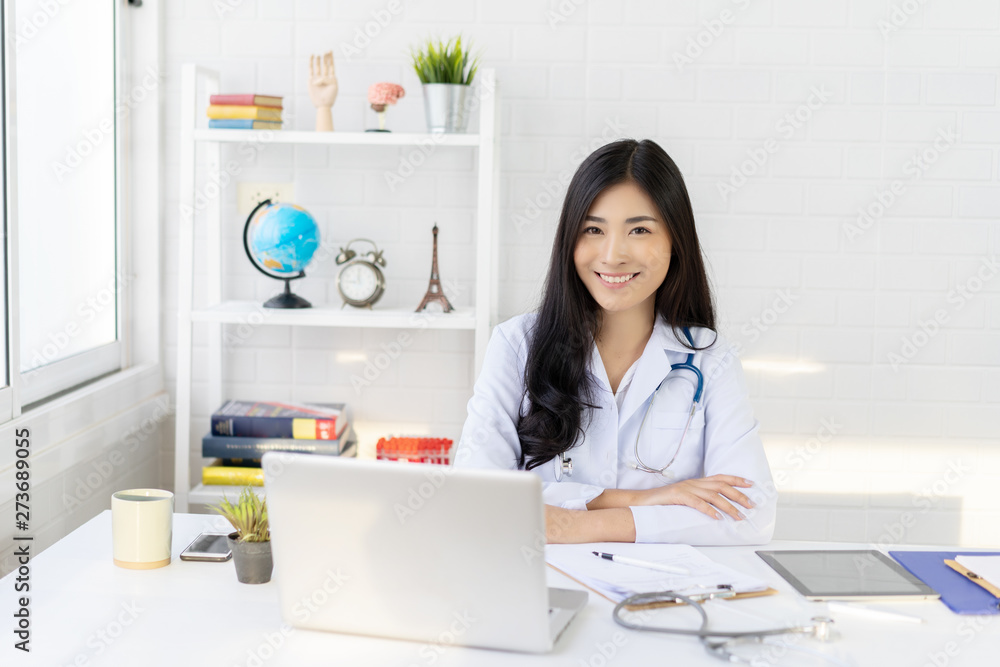 Asian female doctor work at hospital office desk giving patient convenience online service advice, smiling write a prescription order medical with smartphone, health care, preventing disease concept. Asian female doctor work at hospital office desk giving patient convenience online service advice, smiling write a prescription order medical with smartphone, health care, preventing disease concept.