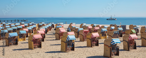 a panoramic photo of colorful beach chairs on the beach in beautiful weather
