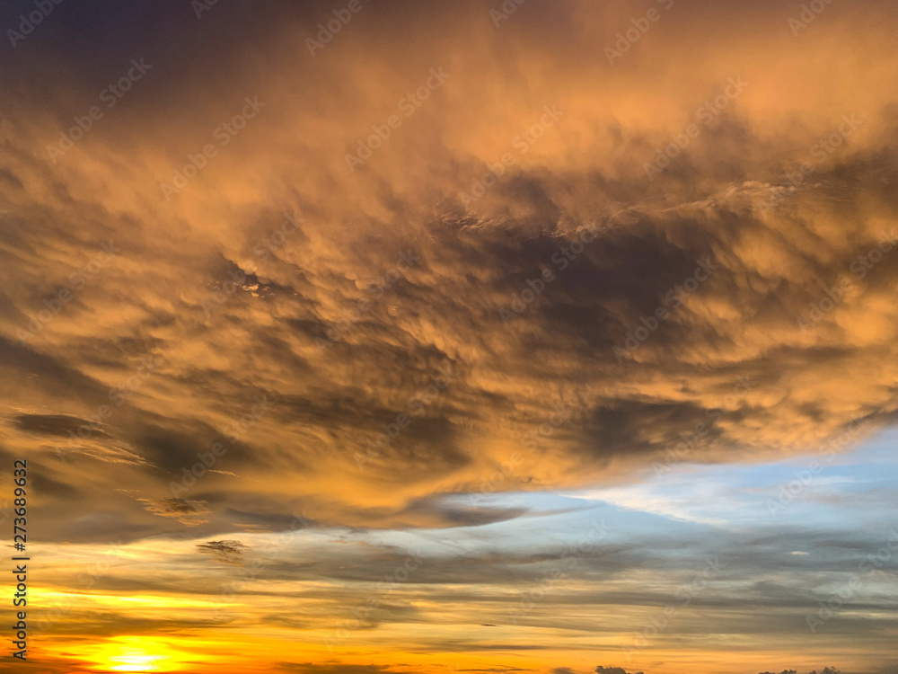 Dramatic sky with clouds on gold and red colour. Abstract of Storm cloudy is coming during Sunset over the sky.
