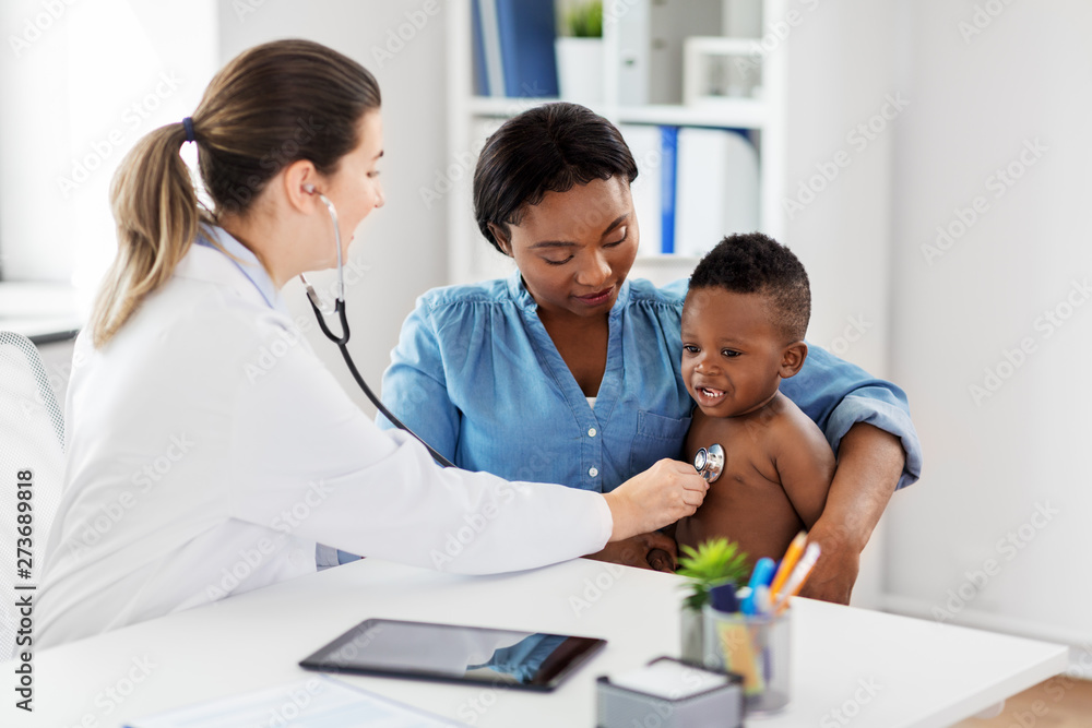 medicine, healthcare and pediatry concept - doctor with stethoscope listening to african american baby boy on medical exam at clinic medicine, healthcare and pediatry concept - doctor with stethoscope listening to african american baby boy on medical exam at clinic