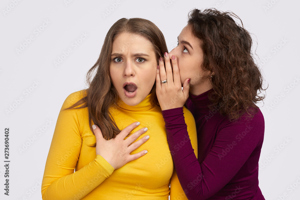 Young female gossiping with friend Young female gossiping with friend